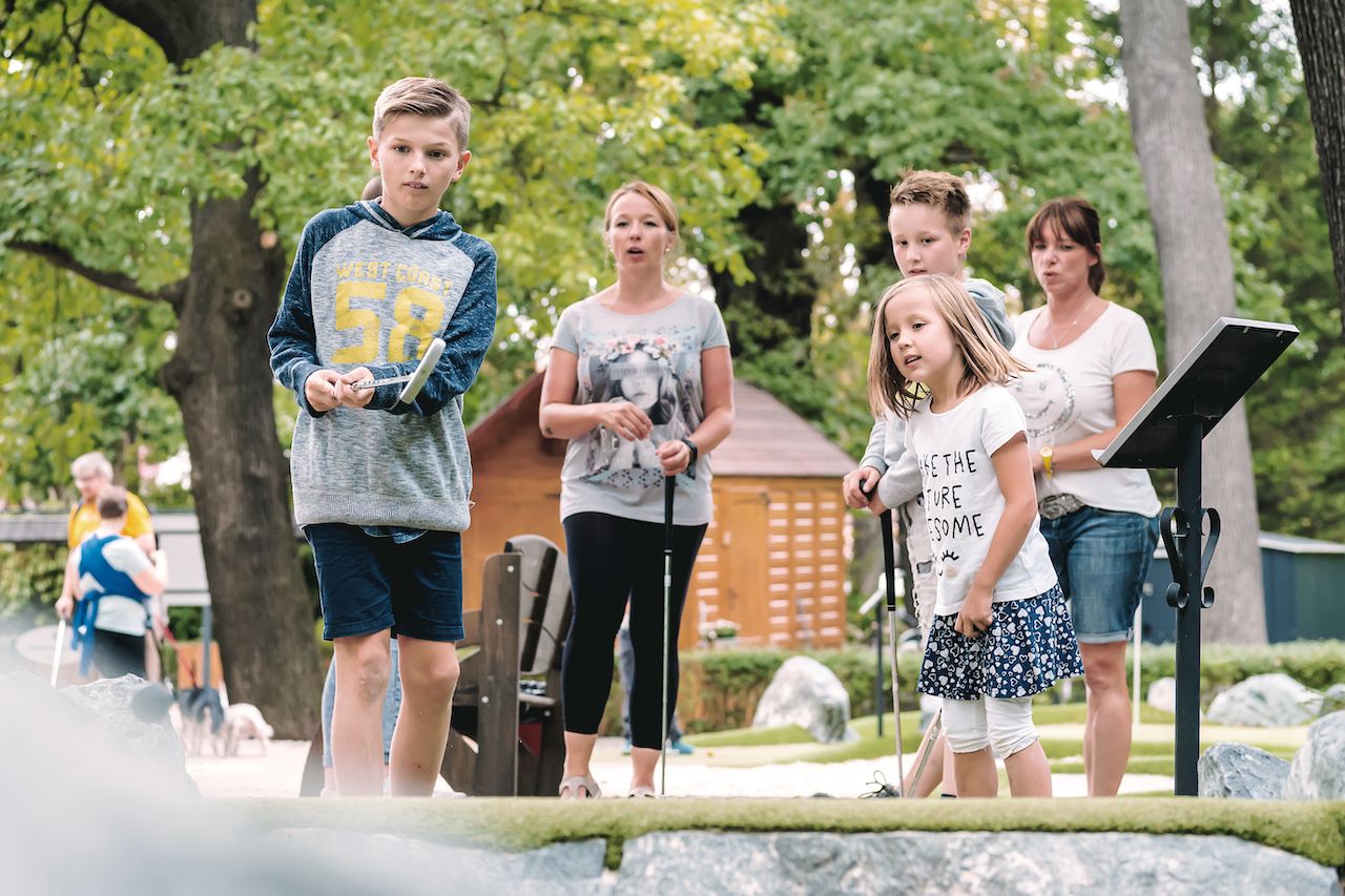 Mutter mit Kind spielt AdventureGolf