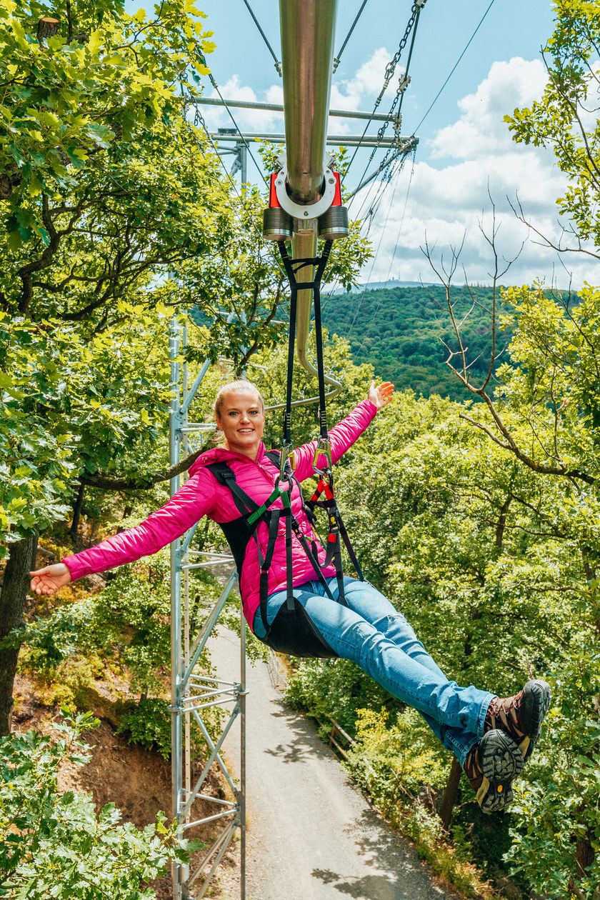 BaumSchwebeBahn Harz, Frau in pink schwebt mit Brockenblick